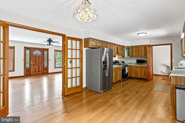a kitchen with stainless steel appliances a refrigerator and wooden floor