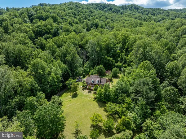 a front view of a house with a garden and tree