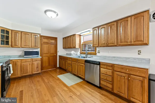 a kitchen with granite countertop wooden cabinets a sink and dishwasher