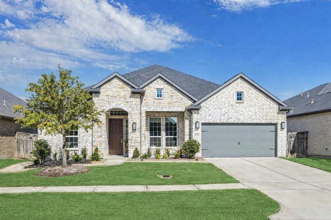 a front view of a house with a yard and garage