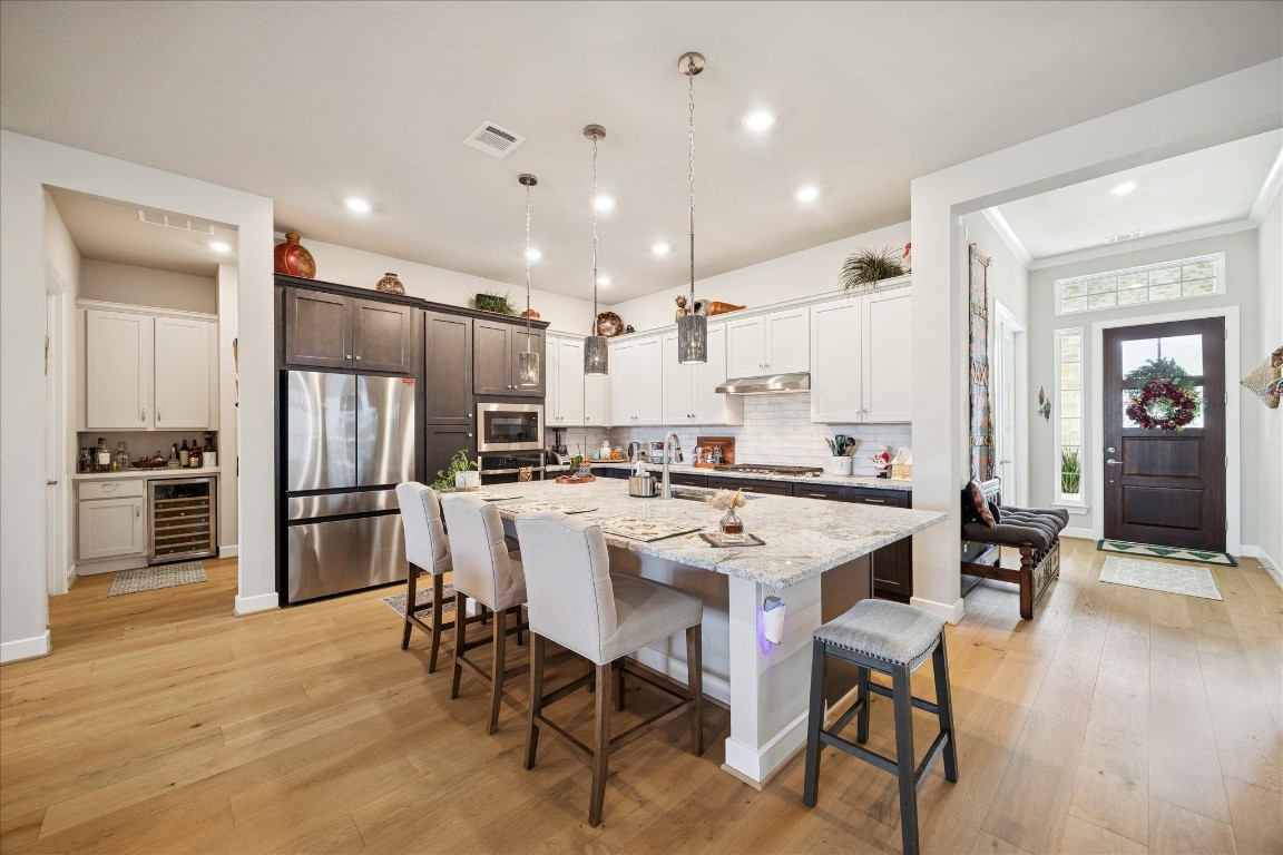 28722 Rising Moon Lane Fulshear, TX 77441 - Photo 12 of 30 a kitchen with a dining table cabinets appliances and wooden floor
