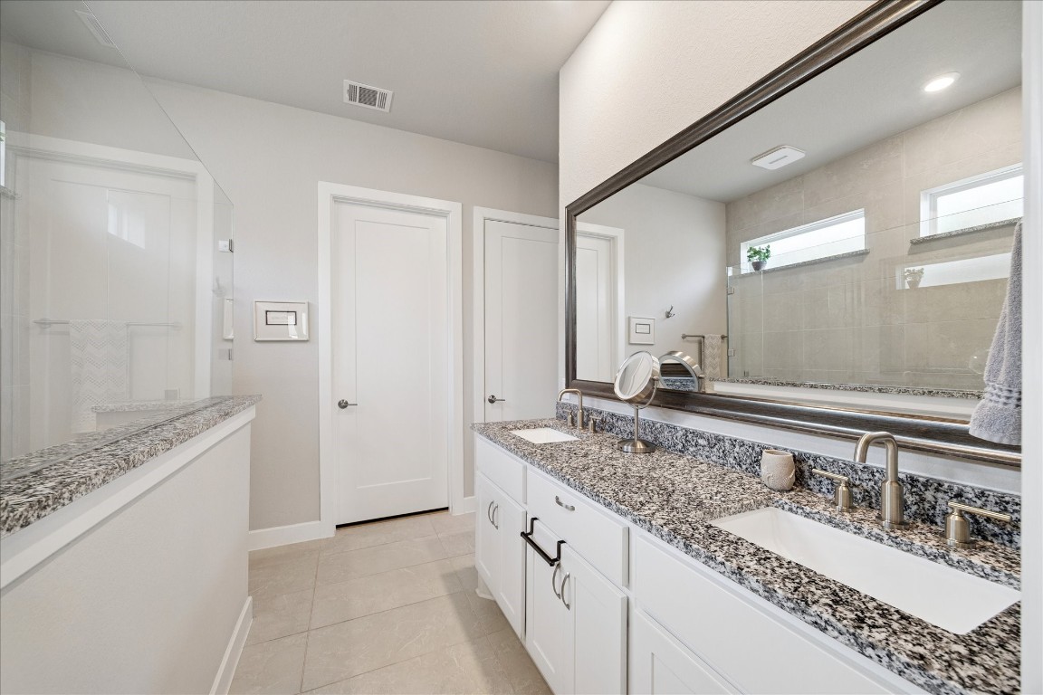 28722 Rising Moon Lane Fulshear, TX 77441 - Photo 21 of 30 a bathroom with a granite countertop double vanity sink and a mirror