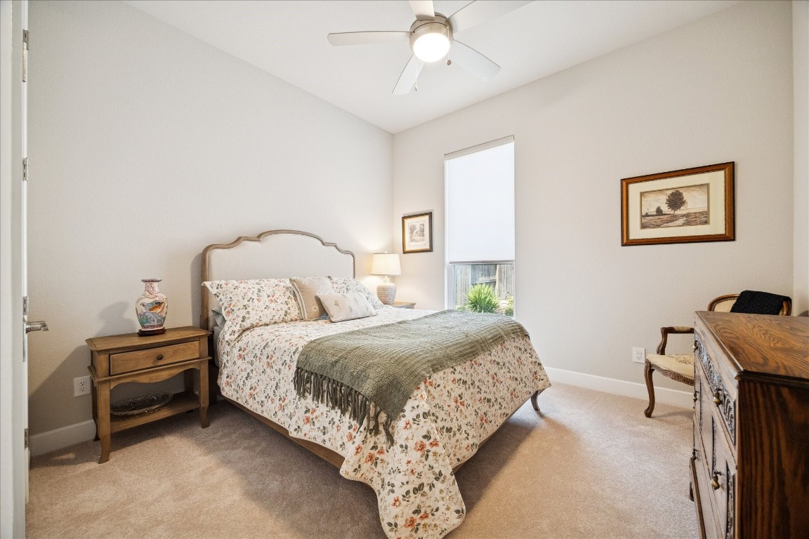 28722 Rising Moon Lane Fulshear, TX 77441 - Photo 22 of 30 a bedroom with a bed and a chandelier