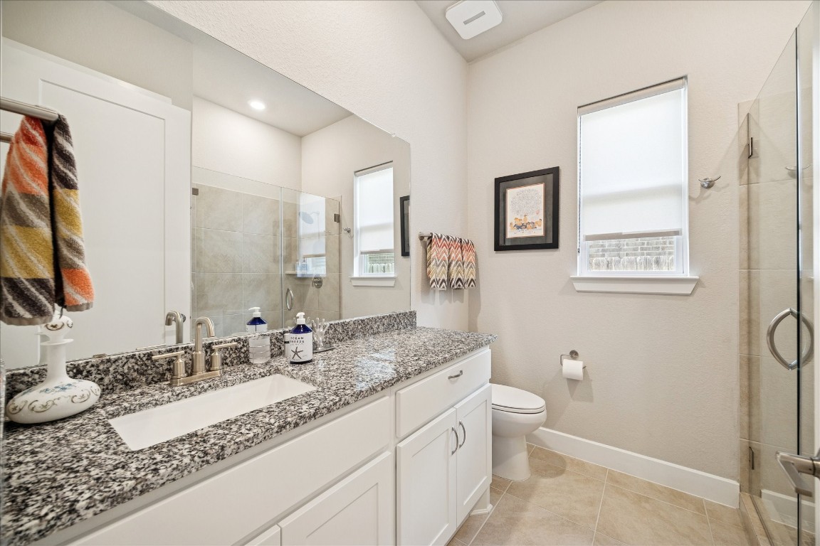 28722 Rising Moon Lane Fulshear, TX 77441 - Photo 23 of 30 a bathroom with a granite countertop sink mirror vanity and toilet