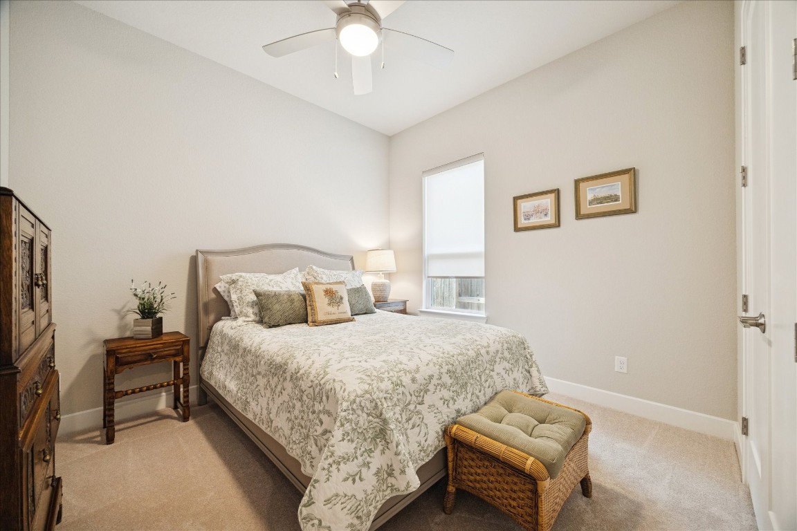 28722 Rising Moon Lane Fulshear, TX 77441 - Photo 24 of 30 a bedroom with a bed and a chandelier