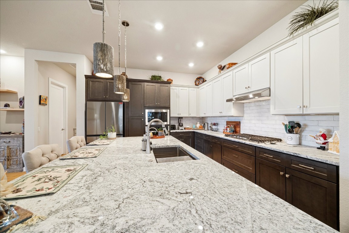 28722 Rising Moon Lane Fulshear, TX 77441 - Photo 8 of 30 a kitchen with stainless steel appliances kitchen island granite countertop a sink stove and refrigerator