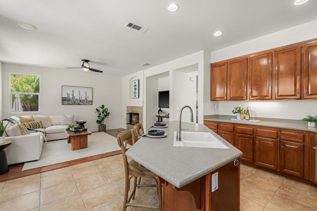 5439 Foxtail Loop Carlsbad, CA 92010 - Photo 16 of 47 a kitchen with a dining table chairs and white cabinets