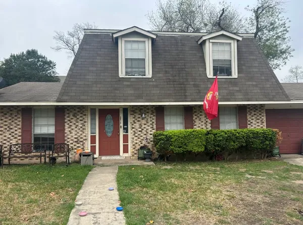 a front view of a house with a yard and potted plants