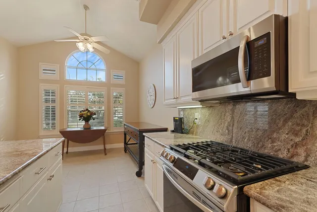a kitchen with stainless steel appliances a stove a microwave cabinets and a window