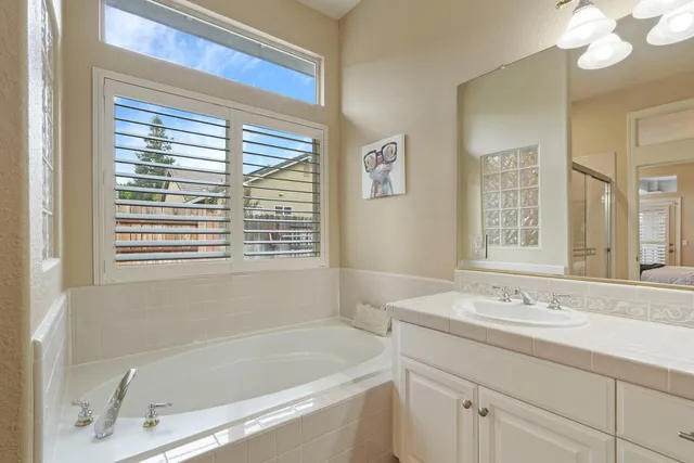 a bathroom with a tub a sink and a window