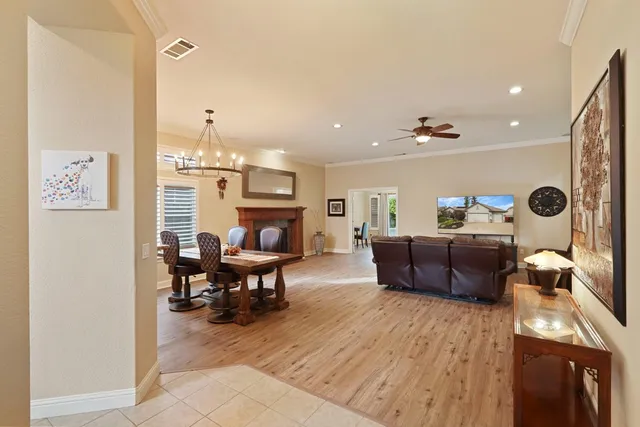a living room with furniture a fireplace and a dining table with wooden floor