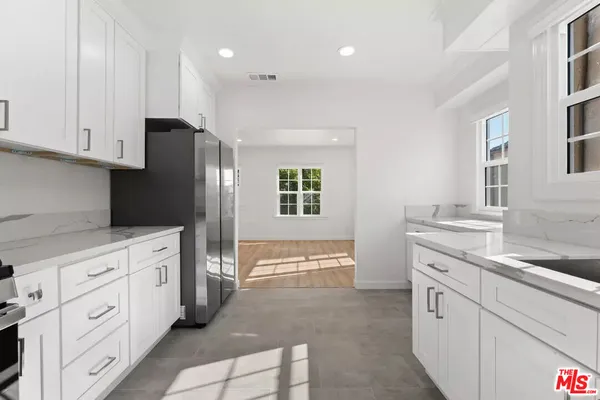 a kitchen with white cabinets and appliances