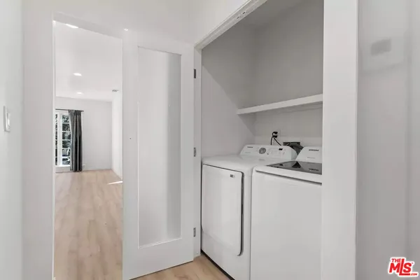 a utility room with cabinets washer and dryer