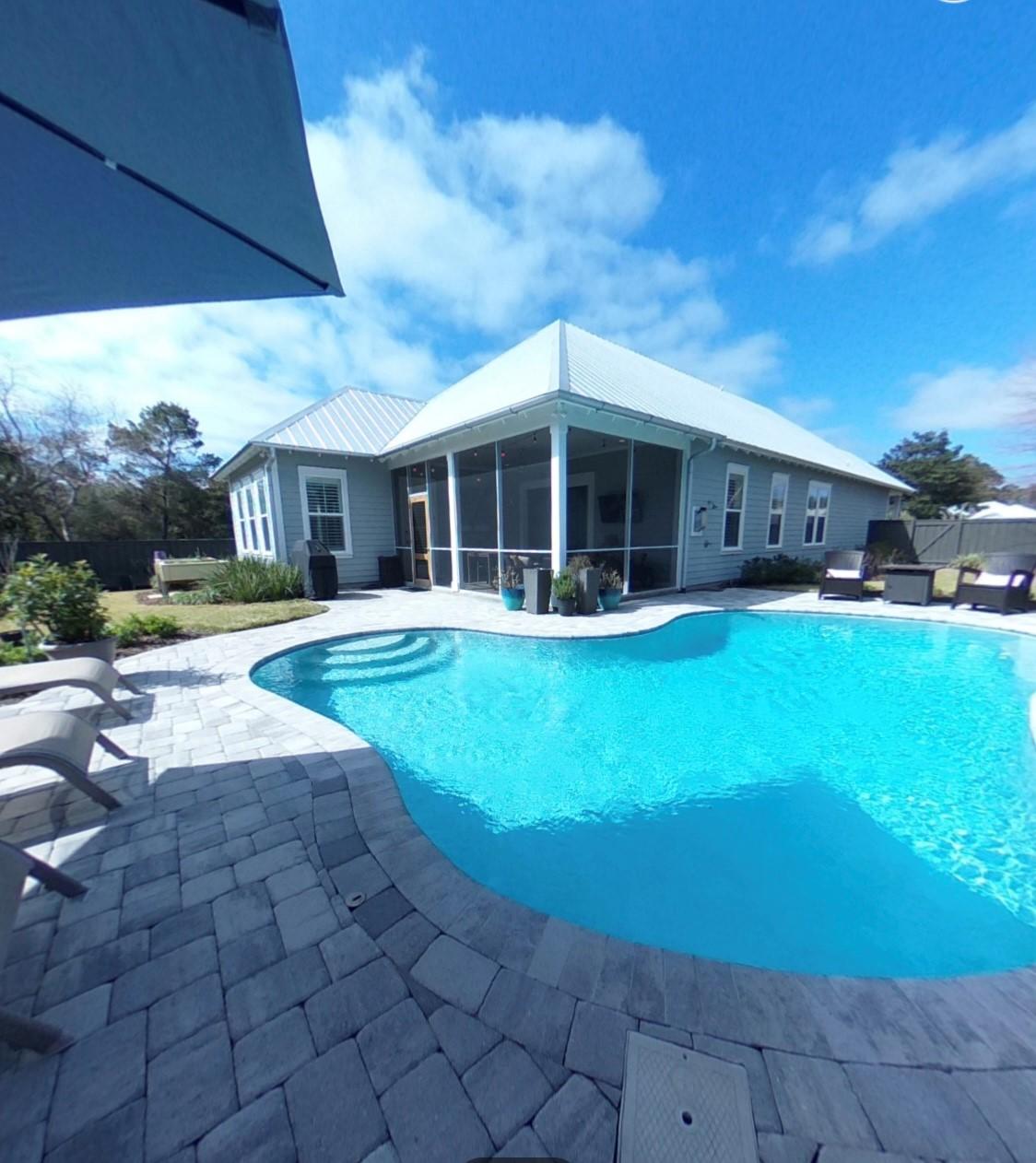 a view of a house with sitting area and swimming pool