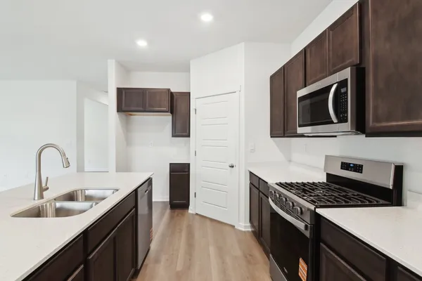 a view of kitchen with microwave a stove and wooden floor
