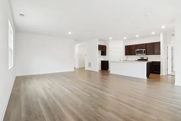 a view of an empty room with a kitchen