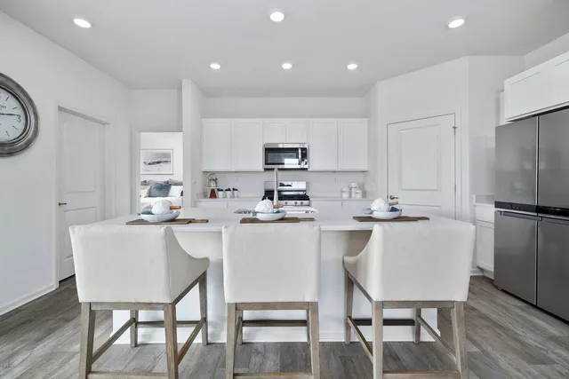 a kitchen with a table chairs a stove a microwave and cabinets