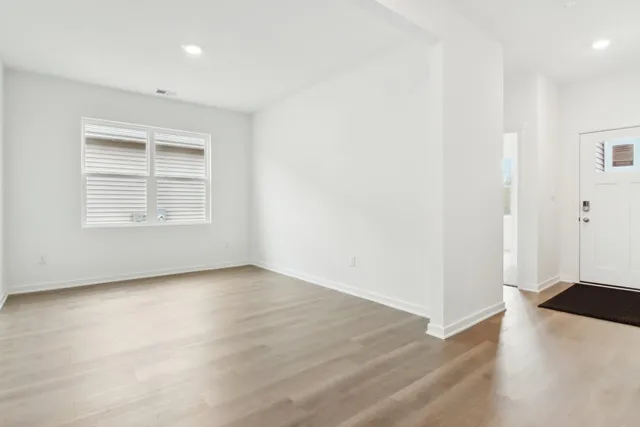 a view of an empty room with wooden floor