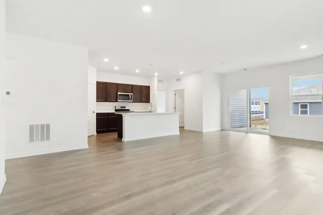 a kitchen with stainless steel appliances a microwave sink refrigerator and cabinets