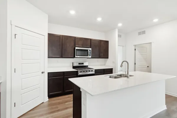 a kitchen with stainless steel appliances a microwave a sink and cabinets