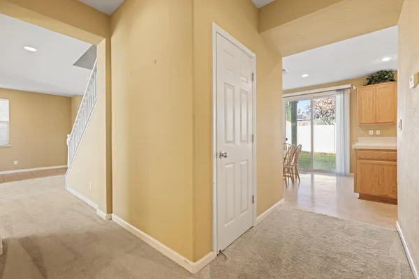 a view of a hallway with wooden floor and cabinet