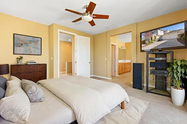 a spacious bedroom with a bed a couch and a chandelier