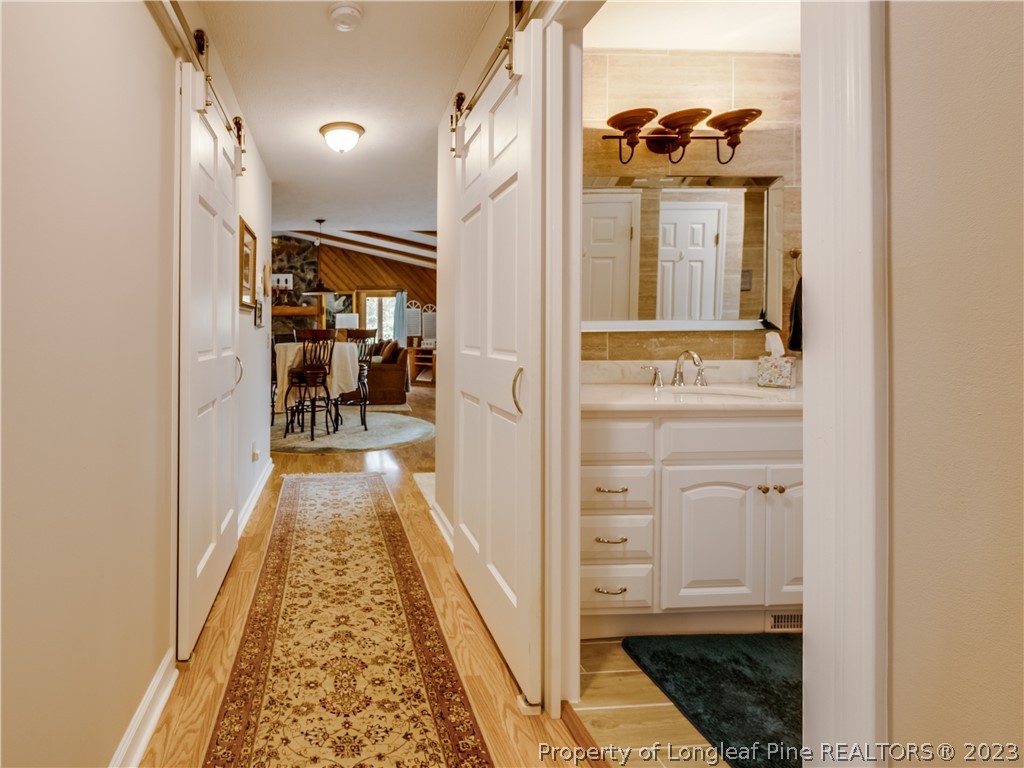 2947 Smith Mill Road Lumberton, NC 28358 - Photo 20 of 50 a hallway with white cabinets and wooden floor