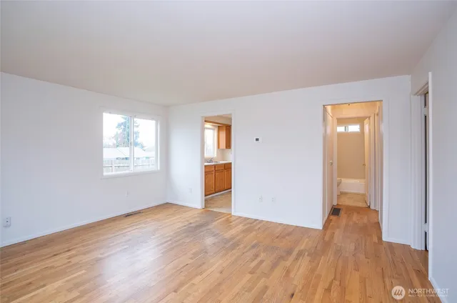 a view of empty room with wooden floor