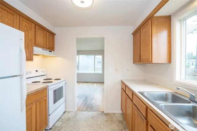 a kitchen with stainless steel appliances granite countertop a sink and a refrigerator
