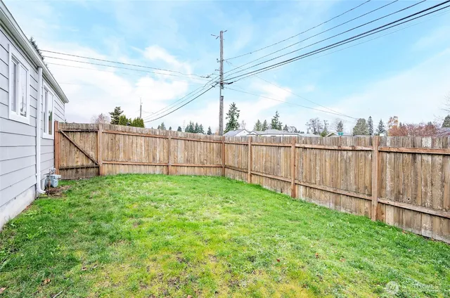 a view of a backyard with wooden fence