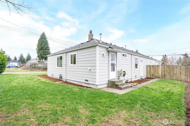 a view of a backyard with couches under an umbrella