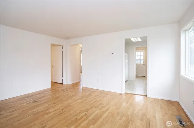 a view of an empty room with wooden floor