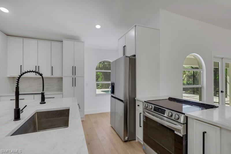 440 33rd Avenue Northeast Naples, FL 34120 - Photo 20 of 34 a kitchen with granite countertop a stove and a refrigerator