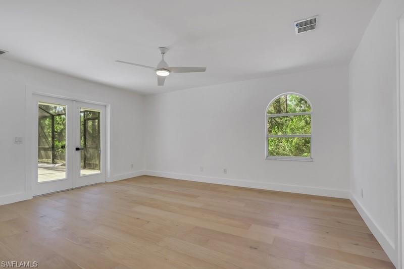 440 33rd Avenue Northeast Naples, FL 34120 - Photo 23 of 34 an empty room with windows and chandelier fan