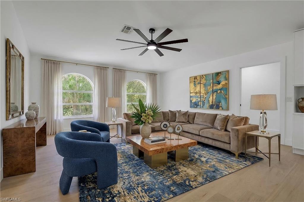 440 33rd Avenue Northeast Naples, FL 34120 - Photo 5 of 34 a living room with furniture a chandelier and a large window