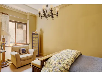 a bedroom with a bed and a flat tv screen on dresser
