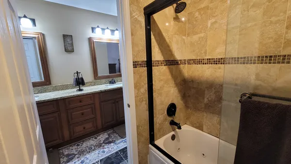 a bathroom with a tub sink and mirror