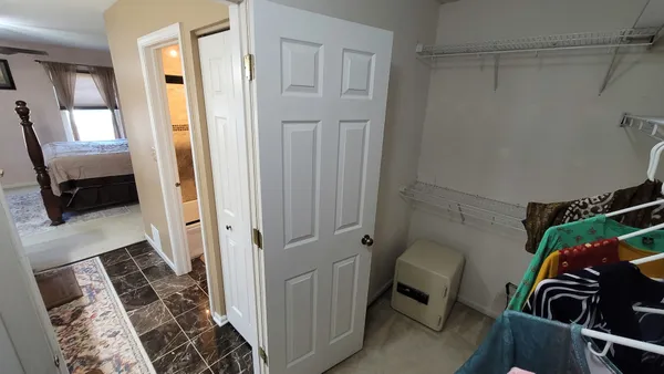 a view of a hallway and a livingroom with furniture