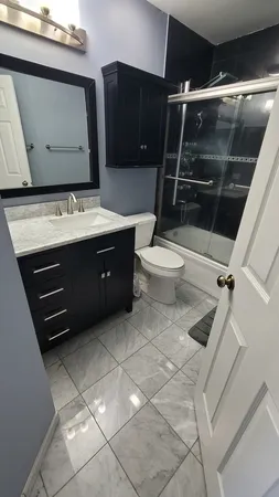 a bathroom with a sink a toilet and shower