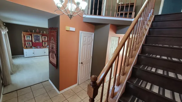 a view of a hallway with entryway and wooden floor