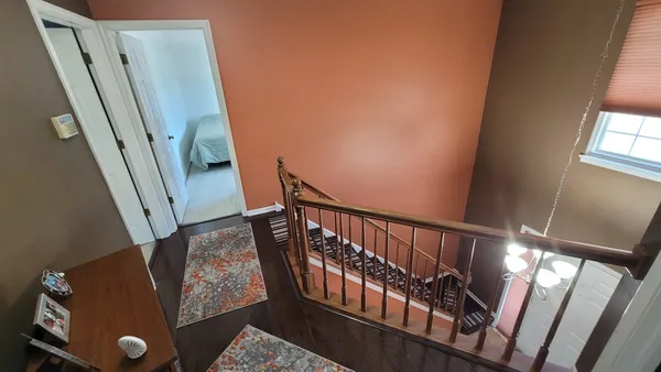 a view of stairs and an entryway with wooden floor