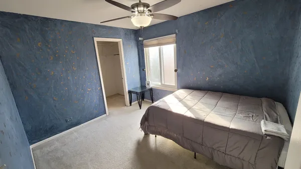 a bedroom with a bed and a chandelier