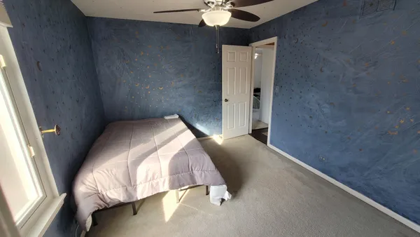 a bedroom with a bed and a chandelier