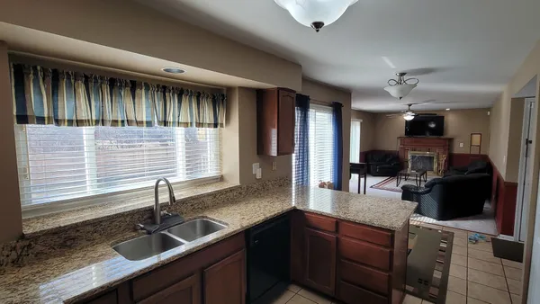 a kitchen with granite countertop a sink stainless steel appliances and cabinets