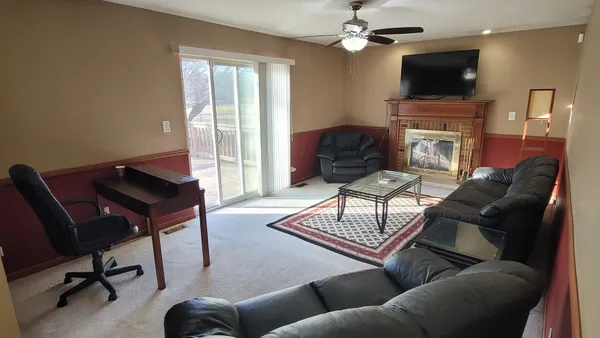 a living room with furniture a flat screen tv and a fireplace