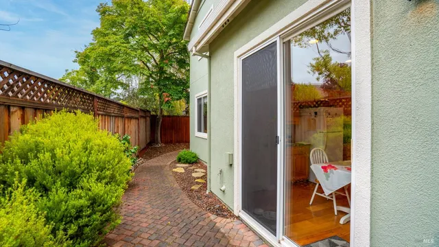 a view of a backyard with a chair and table and potted plants