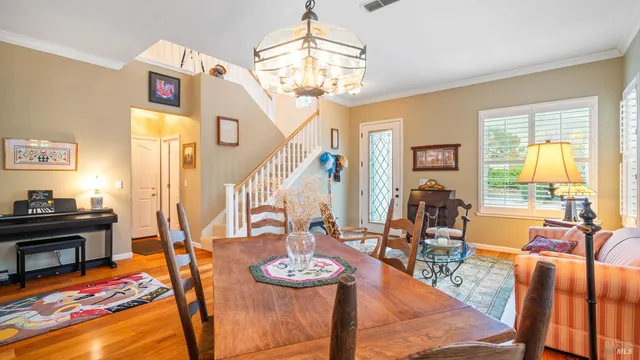 a view of a dining room with furniture a chandelier and large windows