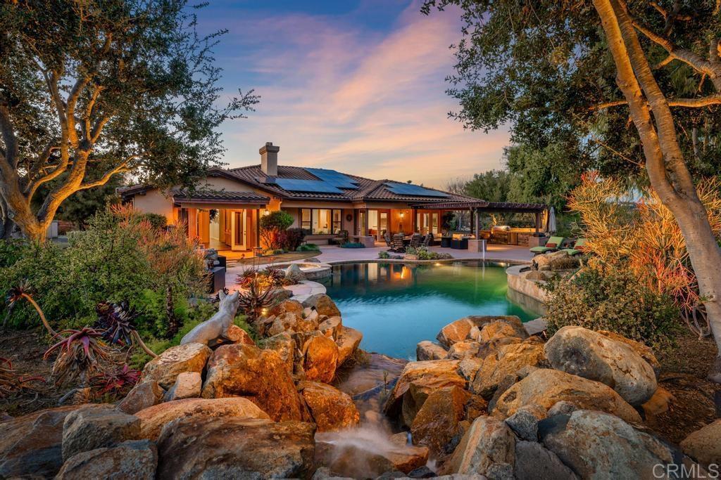 a view of a lake with a house swimming pool and outdoor seating