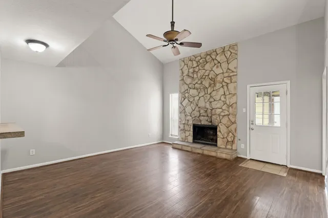 a view of a livingroom with wooden floor a fireplace and windows