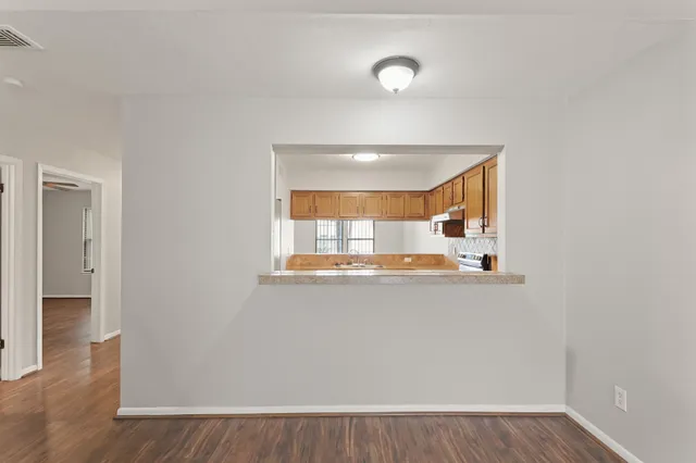 a view of a kitchen with wooden floor and a window